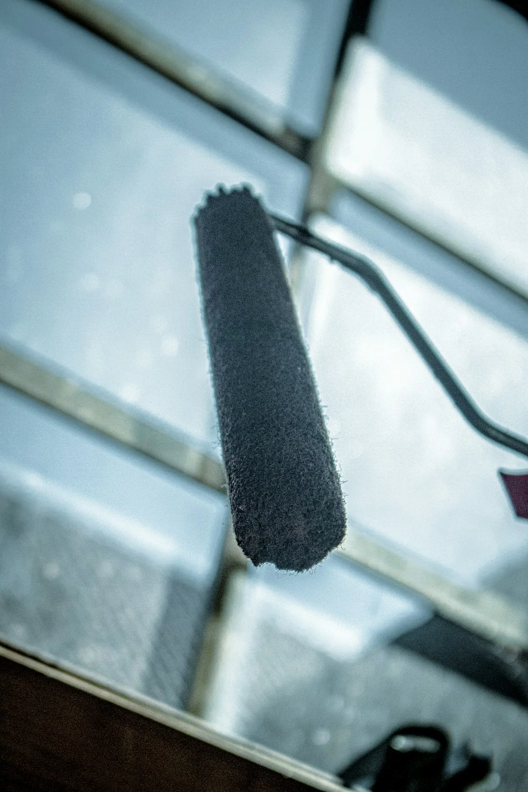 A high-rise glass facade with a suspended platform used for window cleaning.